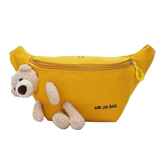 Sacoche banane de couleur jaune avec fermeture à zip jaune accompagné d'une peluche ourson avec un ourson amusé. 